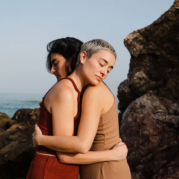 Two woman hugging at beach