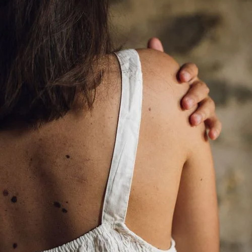 Back view of women holding her arm