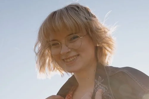 Women with glasses and short blonde bob smiling at camera