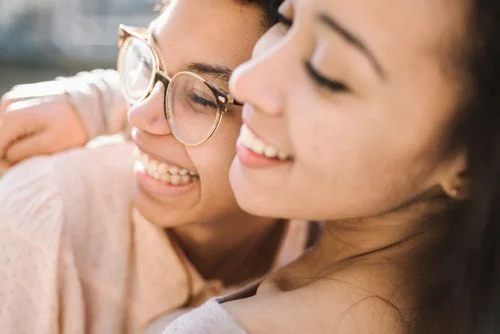 Close up of two young woman hugging